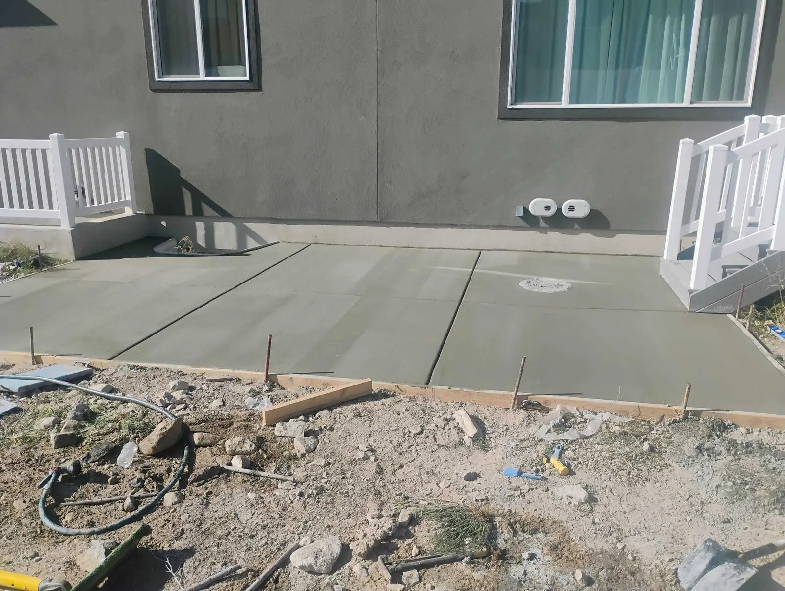 New concrete patio and walkway behind a home