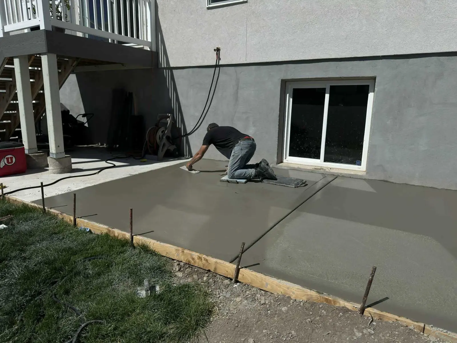 Concrete worker finishing a newly poured backyard patio