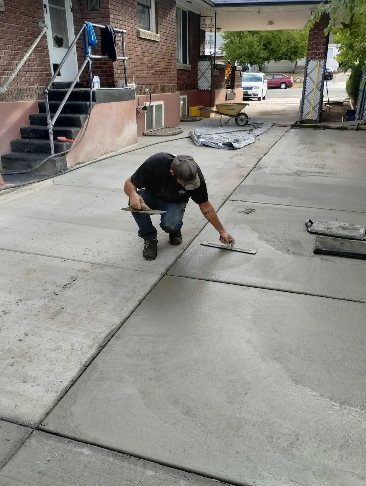 Concrete worker finishing a residential driveway surface